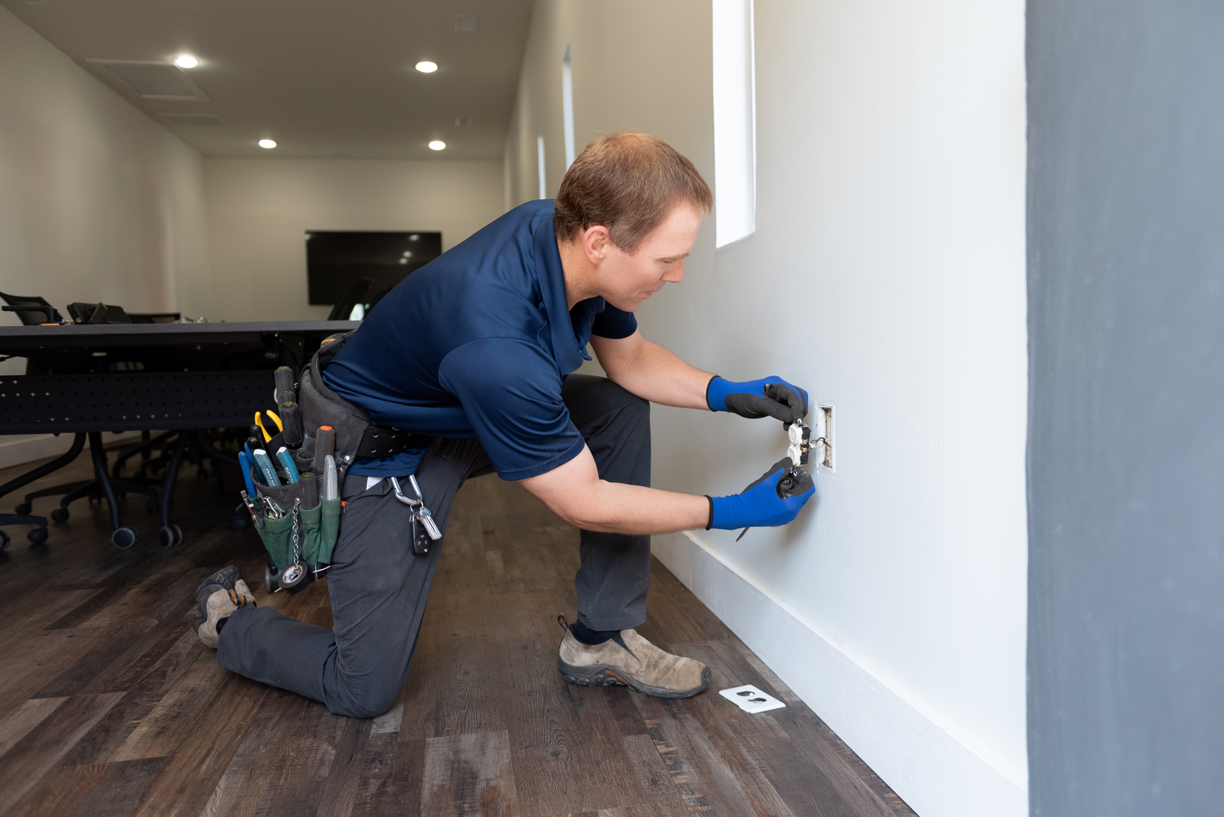 A Travis Crawford electrician repairs an outlet in Charlotte, NC